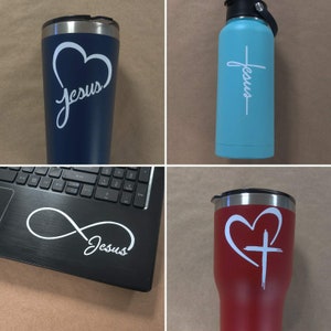 May include: Four different tumblers with various designs featuring the word "Jesus". The designs include a heart, a cross, and an infinity symbol.