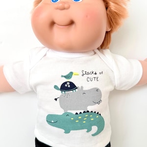 May include: A set of three ceramic mugs with a speckled, matte finish. The mugs are in shades of cream, light gray, and dark gray. Each mug has a simple, minimalist design, perfect for coffee or tea.