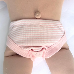 May include: A pair of light pink and white horizontally striped baby underwear featuring a solid light pink ribbed trim along the leg openings and a central snap closure at the crotch, worn on a doll with a visible belly button.