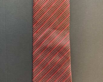 May include: A red and white striped silk tie. The stripes are diagonal and the tie has a pointed tip.
