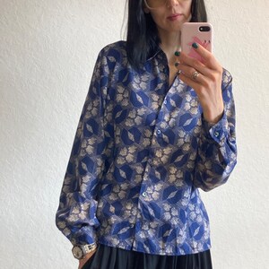 Pu&ograve; includere: Una camicia a maniche lunghe blu e bianca con motivo e chiusura con bottoni. La camicia ha una vestibilit&agrave; rilassata ed &egrave; realizzata in un tessuto leggero.