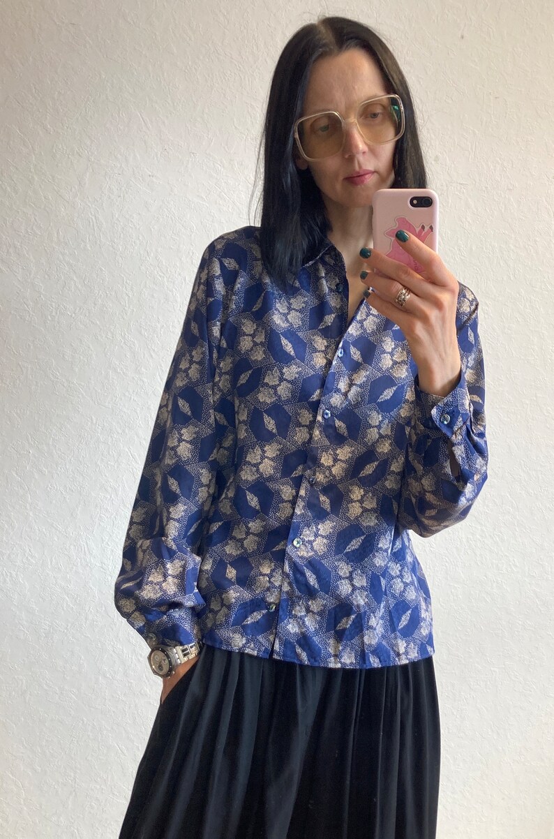 Pu&ograve; includere: Una camicia a maniche lunghe blu e bianca con motivo e chiusura con bottoni. La camicia ha una vestibilit&agrave; rilassata ed &egrave; realizzata in un tessuto leggero.