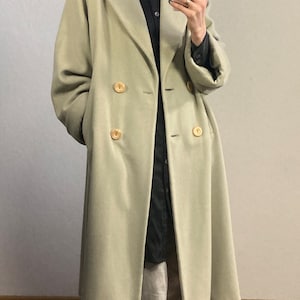 May include: A light green double-breasted coat with large pockets and gold buttons.