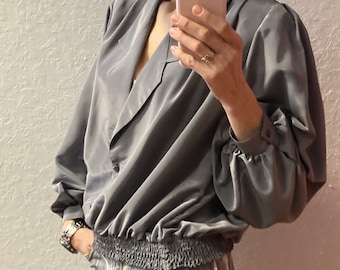 Giubbotto bomber grigio con blusa a pieghe anni ’80