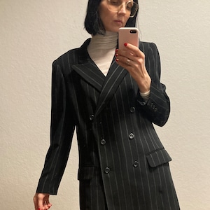 May include: A black and white striped blazer with a double-breasted closure and long sleeves.
