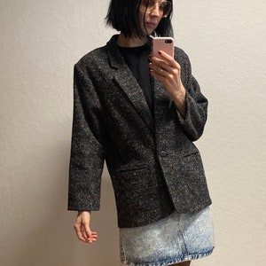 Könnte beinhalten: Ein schwarzer Tweed-Blazer mit einem einzigen Knopfverschluss und einem hellblauen Jeansrock.