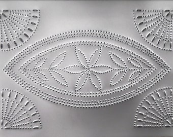 Puede incluir: Una decoración de pared de metal plateado con un diseño en relieve de una estrella de explosión y un óvalo con un patrón floral. El diseño se crea con pequeños puntos espaciados uniformemente.