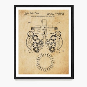 May include: A black and white line drawing of an ophthalmic refractor, a device used to measure eye refraction. The drawing is on a vintage-style parchment background. The patent number US 6,692,128 B2 and date of patent February 17, 2004 are included in the image.
