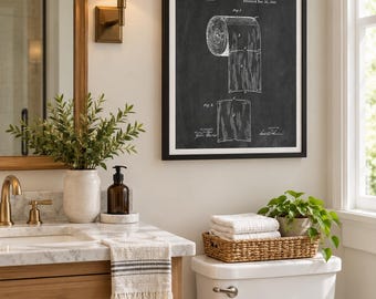 May include: A framed wall art print featuring a black and white patent illustration of a toilet paper roll by S. Wheeler, dated December 22, 1891. The technical drawing shows the roll and a single sheet, displayed in a simple black frame.