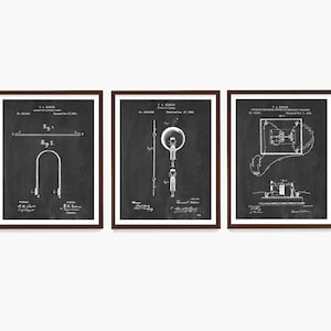 Op de afbeelding: Drie ingelijste patentprints met vintage elektrische schema's. De prints zijn in zwart-wit, met gedetailleerde illustraties van vroege elektrische apparaten. De frames zijn donkerbruin van kleur en de achtergrond is in schoolbordstijl.