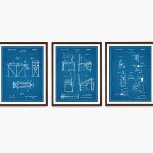 May include: Three blue patent drawings in brown frames. The drawings depict different types of exercise equipment. The first drawing shows a device for exercising the arms and legs. The second drawing shows a device for exercising the back and shoulders. The third drawing shows a device for exercising the legs.