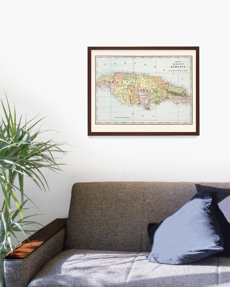 May include: A vintage map of the island of Jamaica, printed in color, with a brown frame. The map shows the island's counties and major cities.
