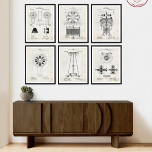 Op de afbeelding: Set van zes vintage zwart-wit elektrische engineering patent prints. De prints bevatten illustraties van verschillende soorten elektromotoren en generatoren. De prints zijn ingelijst en worden weergegeven op een muur boven een houten kast.