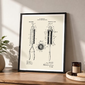 May include: A framed patent print featuring black technical line drawings of an electric curling iron on a cream background. The text includes W. Meredith, Electric Curling Iron, 900,292, Patented Oct. 6, 1908, Fig 1, Fig 2, and Fig 3 with labels.