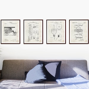 May include: Four framed vintage patent prints. Each print features a detailed black and white technical drawing. The prints are displayed above a gray sofa with pillows and a blue blanket. The frames are dark brown.