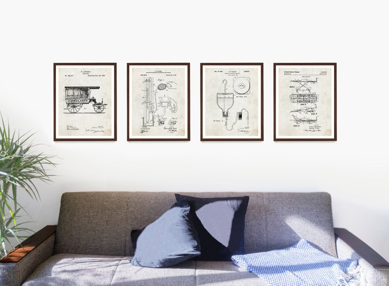 May include: Four framed vintage patent prints. Each print features a detailed black and white technical drawing. The prints are displayed above a gray sofa with pillows and a blue blanket. The frames are dark brown.
