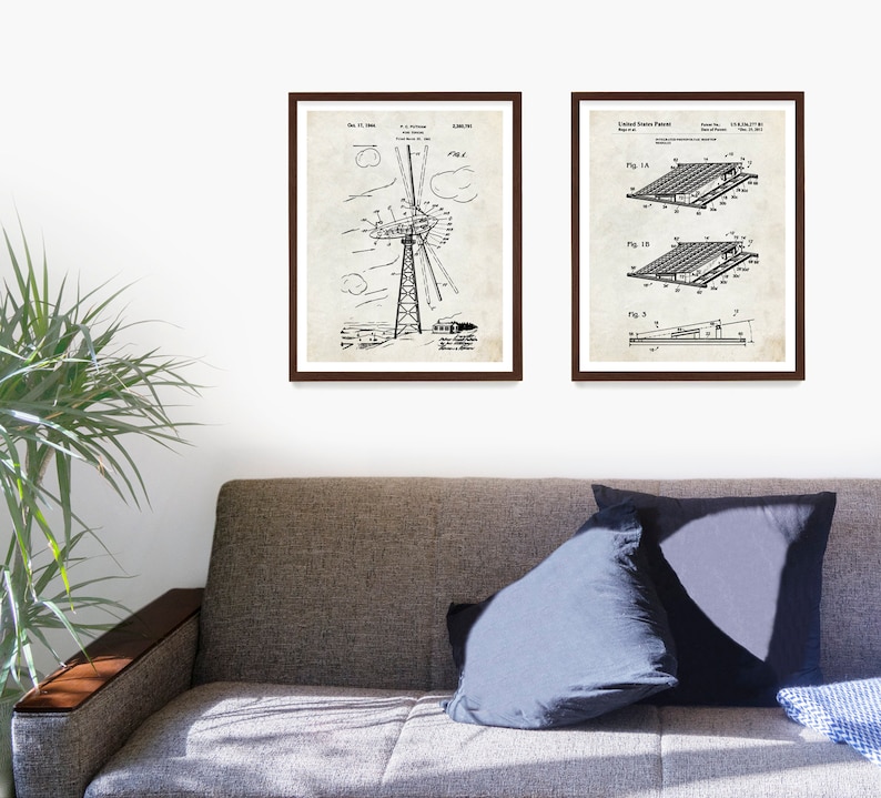 May include: Two black and white vintage patent drawings in brown frames. The left drawing shows a windmill design. The right drawing shows a solar panel design. The drawings are on a white wall above a brown couch.