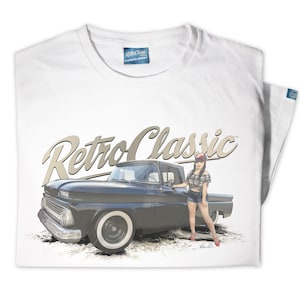 May include: White t-shirt with a black and white illustration of a vintage pickup truck and a woman in a plaid shirt and denim shorts. The text "Retro Classic" is written in a stylized font above the image.