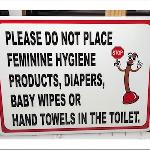 Könnte beinhalten: Ein weißes Schild mit rotem Rand und einer Cartoon-Plunger-Figur. Das Schild lautet "PLEASE DO NOT PLACE FEMININE HYGIENE PRODUCTS, DIAPERS, BABY WIPES OR HAND TOWELS IN THE TOILET." Die Plunger-Figur hält ein rotes "STOP"-Schild.