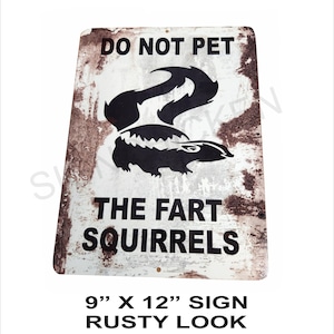 May include: A rusty metal sign with a white background and black text that reads "DO NOT PET THE FART SQUIRRELS". A black silhouette of a skunk is in the center of the sign. The sign is 9 inches by 12 inches.