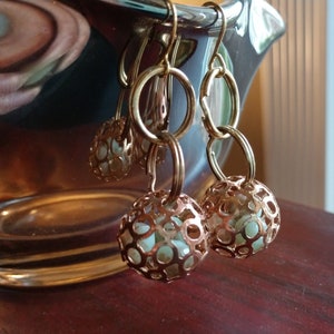 May include: Gold tone earrings with a delicate openwork design and a light green stone in each earring.