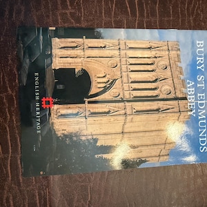 May include: A book cover featuring a detailed architectural image of Bury St Edmunds Abbey. The title is vertically aligned on the right side. The English Heritage logo is visible on the left. The cover has a blue and beige color scheme.