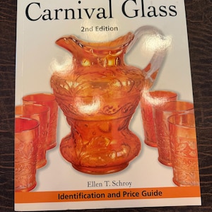 May include: A book titled "Warman's Carnival Glass 2nd Edition" featuring an orange glass pitcher and glasses. The book cover has the title in large black letters with the author's name and the words "Identification and Price Guide".