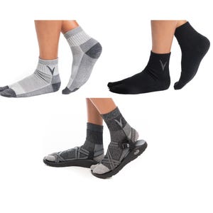 May include: An assortment of toe socks in gray and black, with a gray V-shaped logo on the ankle. One pair is worn with sandals. The socks are designed to separate the big toe from the other toes.
