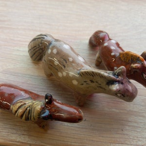 Puede incluir: Tres figuritas de caballos de cer&aacute;mica. Una es marr&oacute;n con manchas blancas, otra es marr&oacute;n con manchas blancas y una crin marr&oacute;n claro, y la &uacute;ltima es marr&oacute;n claro con manchas blancas y una crin marr&oacute;n claro.