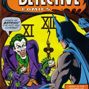 May include: A comic book cover featuring Batman and the Joker. The Joker is holding two green fish with a menacing grin. The cover text reads "Batman's Detective Comics" and "What is the secret of the Joker's new weapon--the laughing fish?"