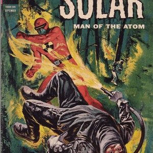 K&ouml;nnte beinhalten: Ein Comic-Cover mit einem Superhelden in einem roten Anzug mit einem gelben Atomzeichen auf der Brust, der gegen einen Schurken in einem schwarzen Anzug und Helm k&auml;mpft. Das Cover ist mit "Doktor Solar, Mann des Atoms" betitelt und der Text "Zum ersten Mal - Solar zeigt sich als der unbesiegbare Mann des Atoms!" befindet sich unten.