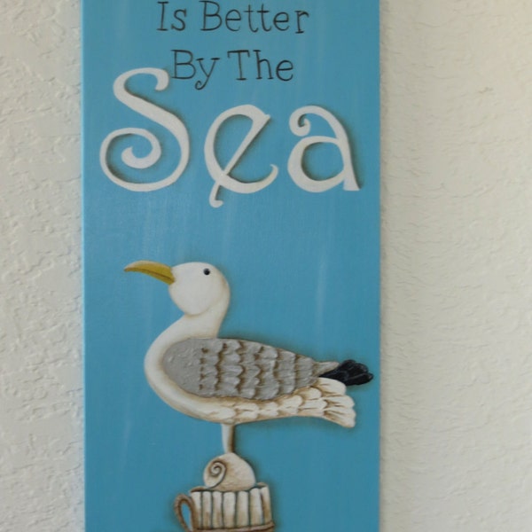 Placa de vida es mejor por el mar con la gaviota y conchas en la viruta