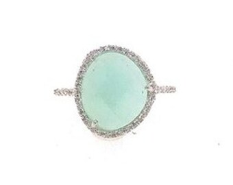 hand-made Aqua Shimmer ring-faceted aqua chalcedony sitting inside a silver surround of cubic zirconias