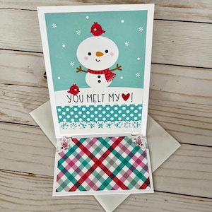 May include: A greeting card featuring a snowman design with a red scarf and a bird on its head. The card reads "YOU MELT MY HEART!" and includes a plaid gift card. The card is on a white envelope.