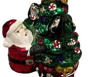 Vintage glazen ornament kerstman en pinguïn in een kerstboom