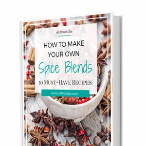 Puede incluir: Una cubierta de libro blanca con un fondo de madera marrón. La cubierta del libro tiene un borde turquesa y un texto que dice "How to Make Your Own Spice Blends 30 Must-Have Recipes" con el sitio web "www.allthatsjas.com". La imagen de fondo muestra un tazón de varias especias, incluyendo anís estrellado, palitos de canela y granos de pimienta.