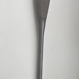 May include: A vintage flathead screwdriver with a dark wooden handle and a metal shaft. The handle is secured with two rivets. The blade shows signs of wear.
