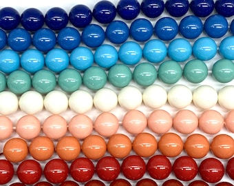 May include: A set of round, smooth, colorful beads in shades of blue, green, white, pink, and red. The beads are arranged in rows, creating a gradient effect.