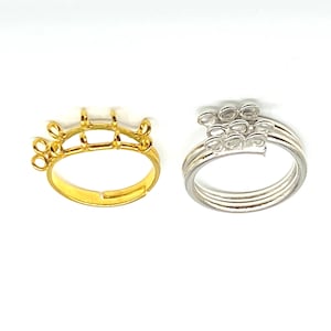 May include: Two adjustable ring blanks for jewelry making. The ring on the left is gold and has five loops. The ring on the right is silver and has eight loops.