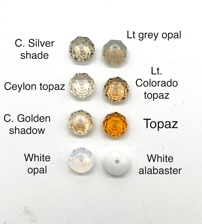 May include: Assortment of 10 round glass beads in various colors and shades, including light grey opal, ceylon topaz, c. golden shadow, topaz, white opal, and white alabaster.