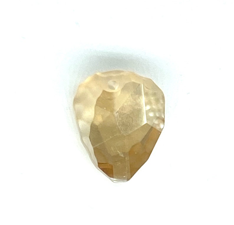 May include: A rough, faceted, light yellow diamond with a heart shape.