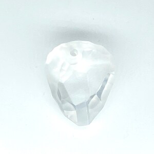 May include: A clear glass crystal bead with a faceted design and a hole in the centre for stringing.