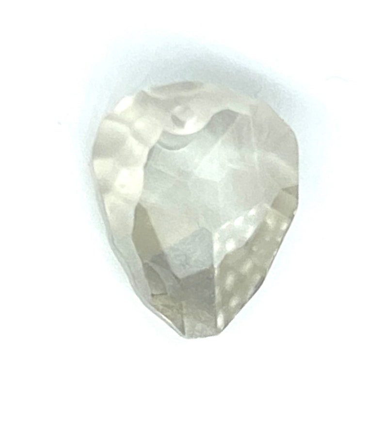 May include: A rough, clear, white diamond with a pear shape.