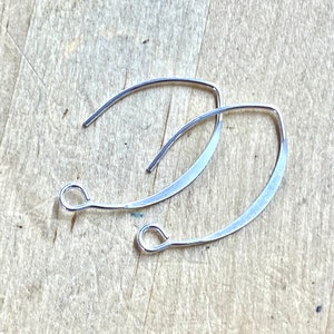 May include: Two silver earring hoops with a curved shape and a small loop at the top.