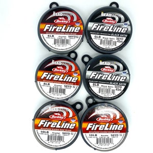 May include: Six spools of Berkley FireLine microfused braided bead thread. The spools are labeled with the line's weight, color, and yardage. The colors are Crystal, Black Satin, and Smoke. The weights are 6lb, 8lb, and 10lb. The yardage is 50 yards.