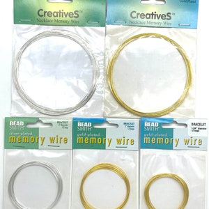 May include: Two packages of silver-plated and gold-plated memory wire, each containing 12 loops of 3.6 inch diameter wire. The packages are labeled "Bead Smith" and "CreativeS Necklace Memory Wire".