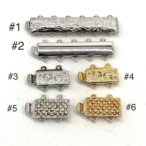 May include: A collection of six metal jewelry clasps in silver and gold tones. The clasps vary in design, including textured, smooth, and engraved patterns. Each clasp has multiple loops for attaching jewelry components. The image includes labels #1 through #6.