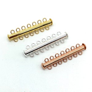 May include: Three metal connector clasps for necklaces or bracelets. The clasps are gold, silver, and rose gold in color. Each clasp has five loops for attaching jewelry.