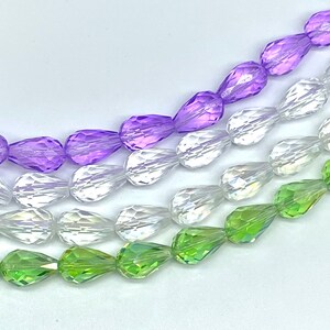 May include: A strand of faceted teardrop glass beads in three colors: light purple, clear, and light green.