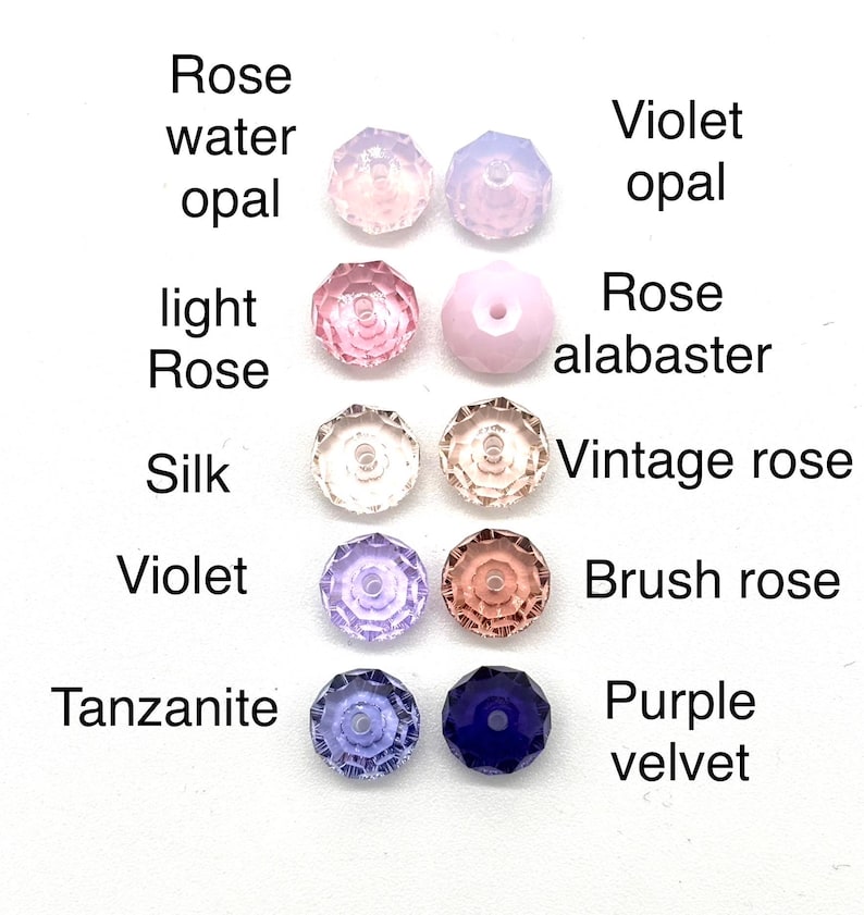 May include: Assortment of 10 round glass beads in various shades of pink, purple, and blue. The beads are labeled with names like "Rose water opal", "Violet opal", "Light Rose", "Rose alabaster", "Silk", "Vintage rose", "Violet", "Brush rose", "Tanzanite", and "Purple velvet".